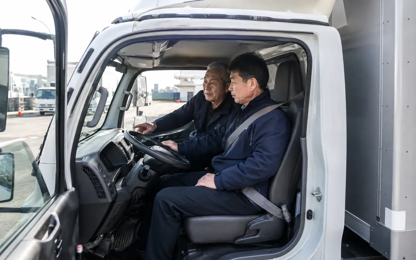 화물차 운전석에서 첫 운행을 준비하는 기사와 담당자